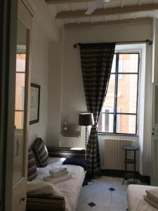 ローマにあるLa Casa In Vetrinaのベッドルーム1室(ベッド2台、大きな窓付)