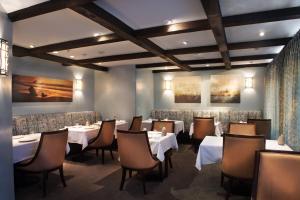 a dining room with white tables and chairs at L'Auberge Carmel, Relais & Chateaux in Carmel