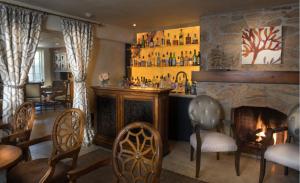 a bar in a restaurant with a fireplace at L'Auberge Carmel, Relais & Chateaux in Carmel