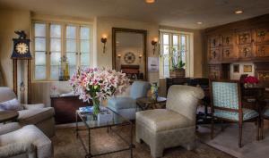 a living room with chairs and a table with a vase of flowers at L'Auberge Carmel, Relais & Chateaux in Carmel