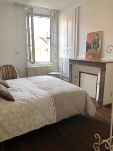 Dormitorio blanco con cama y chimenea en maison Vendeuvre sur barse, en Vendeuvre-sur-Barse