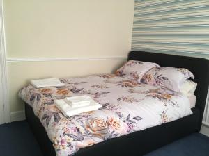 a bed with flowers and towels on top of it at Brookfield’s Apartment in Clacton-on-Sea