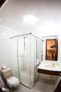 
a bathroom with a shower, toilet and sink at Aquarius Hotel Flat Residence in Santa Cruz do Sul
