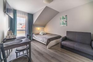 ヤストシェンビャ・グラにあるPokoje i Domki Atlanticのベッド、デスク、椅子が備わる小さな客室です。