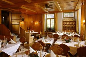 un ristorante con tavoli e sedie in una stanza di Baeren Hotel, The Bear Inn a Wilderswil