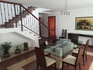 a dining room with a glass table and chairs at Vivienda Unifamiliar Sela in Santa Cruz de Tenerife