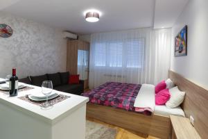 um quarto com uma cama e uma sala de estar em Apartment Promenada 30 em Novi Sad