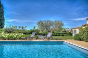 2 sillas sentadas junto a una piscina en Villa Indigo, en Saint-Rémy-de-Provence