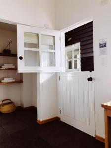 a kitchen with white cabinets and a door at El Establo in Puerto Natales
