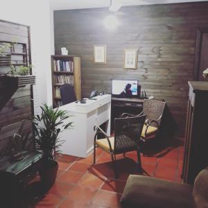 um escritório com uma secretária, um computador e cadeiras em Pousada da Lagoa em Florianópolis