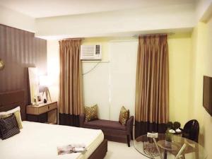 ein Hotelzimmer mit einem Bett, einem Sofa und einem Tisch in der Unterkunft 101 Newport City near NAIA 3, Pasay City in Manila