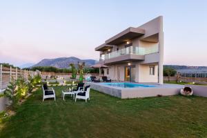 a house with a yard with a pool and chairs at Villa Santa Barbara Herssonisos in Hersonissos
