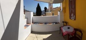 een balkon met een witte muur en een tafel en stoelen bij Casa Kalliroi in Symi