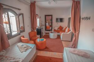 a living room with orange chairs and a couch at Riad Antek in Chefchaouene