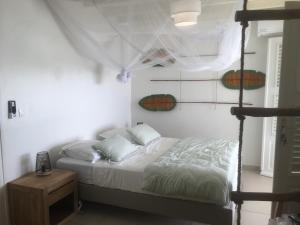 1 dormitorio con 1 cama y escalera a 1 cama en Villa Lauréal, en Grand-Bourg