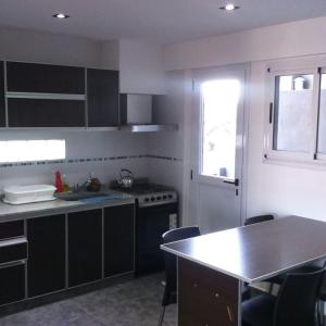 a kitchen with a counter and a sink and a table at Rumbo Sur in Trenque Lauquen