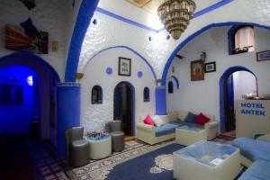 uma sala de estar com paredes azuis e brancas em Riad Antek em Chefchaouene