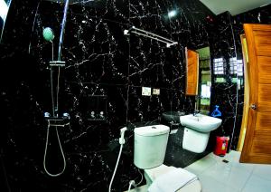 a black bathroom with a toilet and a shower at 4.13 Suites Hotel in Coron