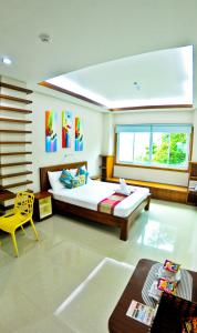 a bedroom with a large bed and a yellow chair at 4.13 Suites Hotel in Coron