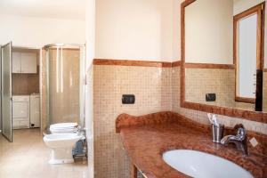 a bathroom with a sink and a toilet and a mirror at ABACA Rooms in Lecce