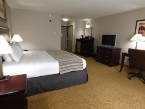 a hotel room with a bed and a flat screen tv at Country Inn & Suites by Radisson, Pensacola West, FL in Pensacola