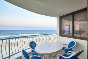 a balcony with a table and chairs and the beach at Albatross North Apartments in Gold Coast