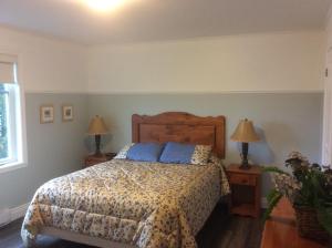 um quarto com uma cama com almofadas azuis em Condo Lac Archambault 298 em Saint-Donat-de-Montcalm