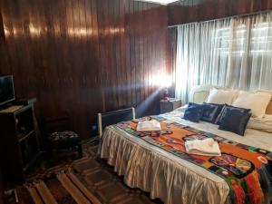 卡塔馬卡的住宿－La Maison，一间卧室设有一张床和木墙