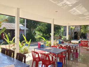 a patio with tables and chairs in a restaurant at Baan Suan Kru Kob in Ban Ko Maphang