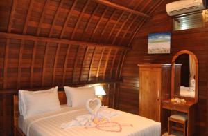 een slaapkamer met een bed en een spiegel bij Setilas Bungalows in Nusa Penida