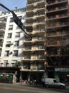 un edificio blanco alto con motos estacionadas frente a él en Callao Suites Recoleta en Buenos Aires