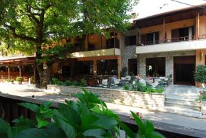 un edificio con tavoli e sedie di fronte ad esso di Hotel Papanastasiou a Elati Trikalon