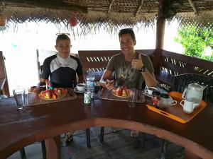 two men sitting at a table with plates of food at Dolphin Village in Kalpitiya