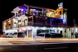 a building with cars parked on a street at night at Mayon Lodging House in Legazpi