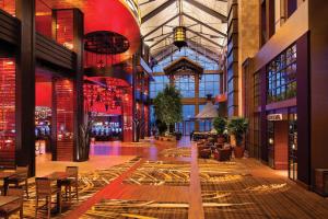 un hall avec des tables et des chaises dans un bâtiment dans l'établissement L'Auberge Baton Rouge, à Bâton-Rouge