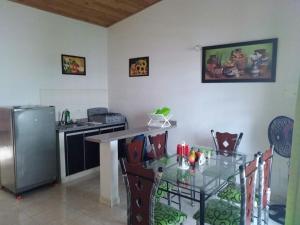 a kitchen with a counter and a table and a refrigerator at Excelente Casa vacacional in Flandes