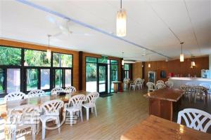 a large room with white chairs and tables and windows at Jingshan Landscape in Zhuolan