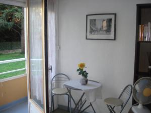 a table with chairs and a vase with a flower on it at Résidence Home 90 in Avignon