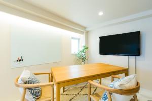 a dining room with a table and a tv at KAGO 34 Tokyo by Shukuba HOTEL in Tokyo