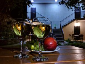 dois copos de vinho sentados numa mesa com fruta em Hotel Beni em Akhaltsikhe