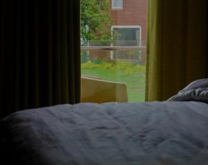a bedroom with a bed looking out a window at Lotus Farms (Pure Veg) in Mahabaleshwar