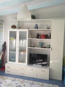 a white entertainment center with a flat screen tv at Villa Azzurra in San Felice Circeo