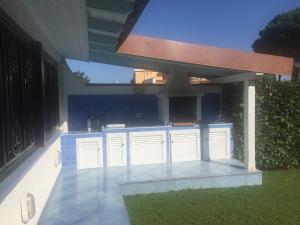 an outdoor kitchen with white cabinets in a backyard at Villa Azzurra in San Felice Circeo