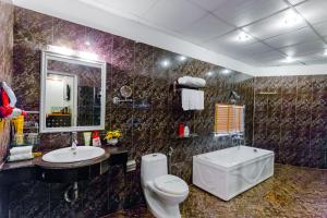 y baño con aseo, lavabo y espejo. en A25 Hotel - 53 Tuệ Tĩnh, en Hanói