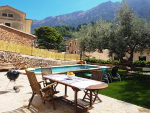 a patio with a table and chairs next to a pool at Can Pera Accommodation - TI in Fornalutx