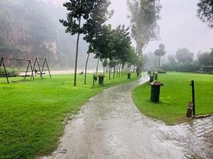 a dirt road in a field in the rain at Riverside By Aahma-Fully Vaccinated Staff in Garjia