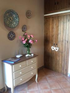 un jarrón de flores en un tocador en una habitación en Hotel Rural Andalucia en Sierra de Yeguas