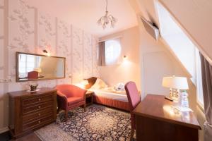 a bedroom with a bed and a desk and a chair at Hotel Haus Müller in Marburg an der Lahn