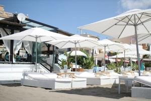 a patio area with chairs, tables and umbrellas at Carihuela Park Palace - Cocasa in Torremolinos