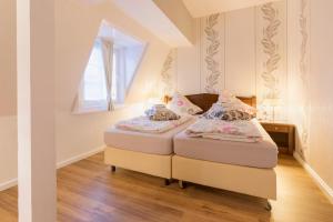 2 Betten in einem kleinen Zimmer mit Fenster in der Unterkunft Hotel Haus Müller in Marburg an der Lahn